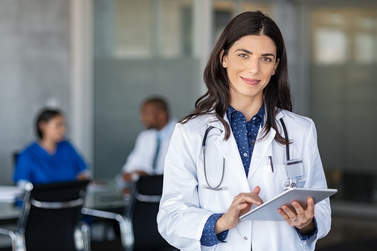 Medical professional in Nashville smiling while using tablet—representing busy professionals who benefit from Nashville laundry delivery services.