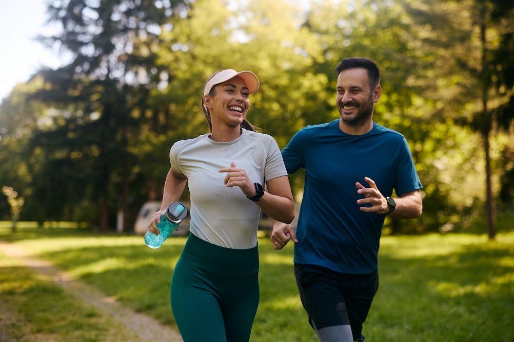 Couple jogging in Nashville park wearing workout clothes, perfect example for best way to wash gym clothes without odors.